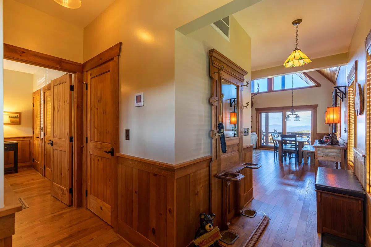 This image shows a cozy dining area near wooden doors, with an entryway bench visible, suggesting easy access to the outdoors. The natural light and inviting atmosphere hint at the transition between indoor and outdoor spaces—ideal for guests preparing to set out on adventures with their pets.